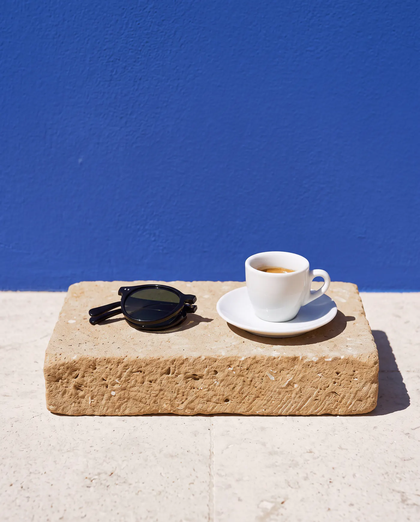 Deià negras plegadas junto a un café en un bloque de marès al sol